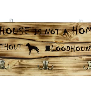 Bloodhound, a wooden wall peg, hanger with the picture of a dog and the words: &quot;A house is not a home without...&quot;