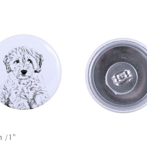 May include: A white button with a black and white illustration of a small dog. The button is 1 inch in diameter.