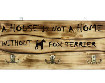 Fox Terrier, a wooden wall peg, hanger with the picture of a dog and the words: "A house is not a home without..."