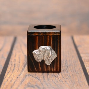 Könnte beinhalten: Ein dunkelbrauner Kerzenhalter aus Holz mit einem silbernen Hundekopfdesign.