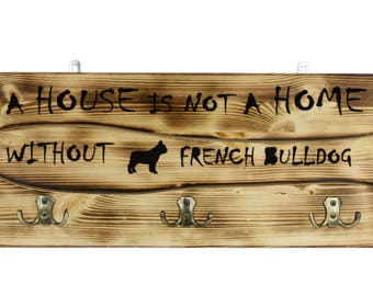 French Bulldog, a wooden wall peg, hanger with the picture of a dog and the words: "A house is not a home without..."