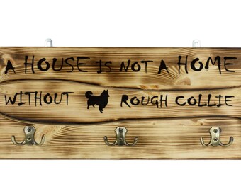 Collie, a wooden wall peg, hanger with the picture of a dog and the words: "A house is not a home without..."