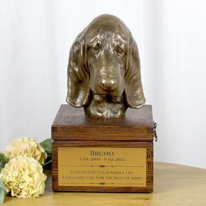 Peut inclure: Une sculpture en bronze d'une tête de chien sur une boîte en bois. La boîte porte une plaque dorée avec le nom "Bruno", des dates et le texte "I LOVED YOU YOUR WHOLE LIFE I WILL MISS YOU FOR THE REST OF MINE."