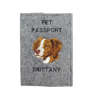 May include: Gray felt pet passport holder with embroidered brown and white dog and the text "PET PASSPORT" and "BRITTANY".