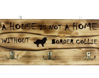Border Collie, a wooden wall peg, hanger with the picture of a dog and the words: "A house is not a home without..."
