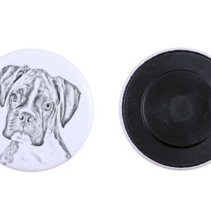 Puede incluir: Un imán redondo blanco con un dibujo en blanco y negro de un perro boxer en la parte delantera. La parte posterior del imán es negra.