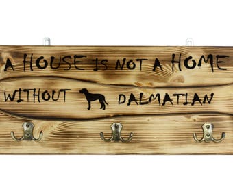 Dalmatian, a wooden wall peg, hanger with the picture of a dog and the words: "A house is not a home without..."