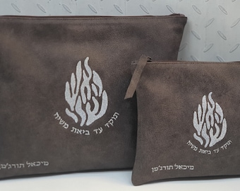 Puede incluir: Dos bolsas de cremallera de ante marrón con un diseño de llama plateada y texto en hebreo. La bolsa más grande tiene el texto "Hodah Ya Hashem" y la bolsa más pequeña tiene el texto "Hodah Ya Hashem Mi Ba'al Chesed."