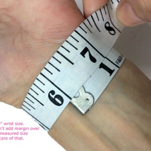 May include: A white measuring tape wrapped around a wrist, showing a measurement of 6 inches. The text "This is a 6" wrist size. Please don't add margin over the tight measured size as I take care of that." is written below the image.
