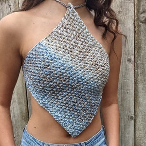 Puede incluir: Un top halter de crochet azul, marrón y blanco con forma de diamante.