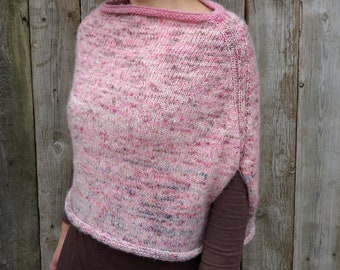 Può includere: Un poncho di maglia rosa e bianco con una vestibilità ampia e spalle leggermente scese. Il poncho ha un design semplice ed elegante ed è realizzato con un filato morbido e confortevole.