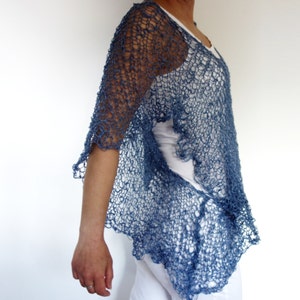 May include: A blue crocheted shawl with a delicate openwork pattern. The shawl is draped over a person's shoulders and falls to the waist.