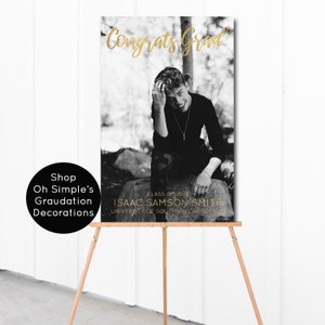 May include: Black and white photo of a graduate in a cap and gown, with the text "Congrats Grad" in gold lettering. The text "Class of 2018" and "Isaac Samson Smith" is also in gold lettering. The text "University of Southern California" is in black lettering.