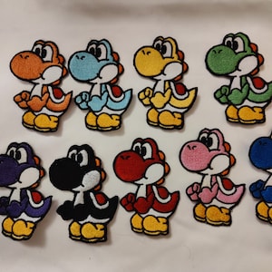 Könnte beinhalten: Eine Sammlung von zehn gestickten Aufnähern mit der Figur Yoshi aus der Super Mario-Videospielserie. Jeder Aufnäher zeigt Yoshi in einer anderen Farbe, darunter Orange, Blau, Gelb, Grün, Lila, Schwarz, Rot, Rosa und Dunkelblau.