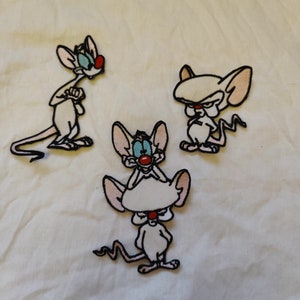 Puede incluir: Tres parches de plancha de ratón de dibujos animados blancos con contornos negros. Los ratones tienen narices rojas y ojos azules. Los ratones están en diferentes poses.