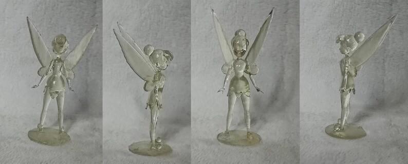 Puede incluir: Una figurita de cristal transparente de Campanita, el hada de la pel&iacute;cula de Disney Peter Pan. La figurita est&aacute; posada con las alas extendidas y los brazos extendidos. La figurita mide aproximadamente 15 cm de alto.