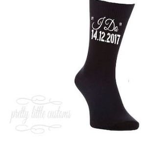 Può includere: Calze nere con ricamo bianco che recita "I Do" e "14.12.2017".