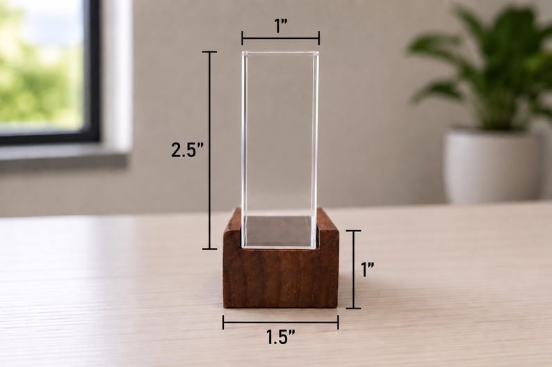 Op de afbeelding: Een doorzichtige rechthoekige acryl displayhouder in een donkerbruine houten voet. De acryl behuizing is 6,35 cm hoog en 2,54 cm breed. De houten voet is 2,54 cm hoog en 3,81 cm breed en is voorzien van een centrale gleuf.