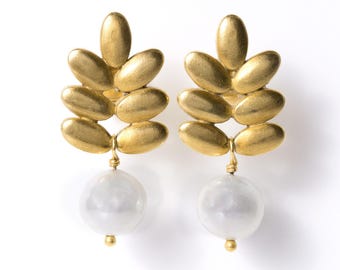 May include: A pair of gold-toned earrings featuring a brushed metal leaf-shaped top section with six oval segments. Each earring is finished with a single, smooth, round white pearl drop suspended from the base of the metallic leaf structure.
