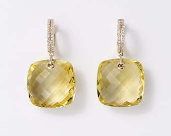 May include: A pair of gold drop earrings featuring large, square-cut, faceted yellow gemstones suspended from hoops. Each hoop is embellished with a row of small, clear, sparkling stones along the front, adding a refined detail to the design.