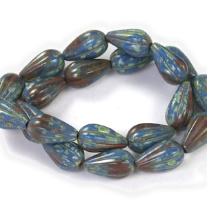 May include: A strand of blue and brown glass beads in a teardrop shape. The beads have a mottled, speckled appearance.