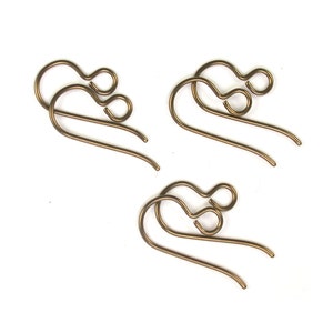 Puede incluir: Tres pares de ganchos para pendientes de color dorado. Cada gancho tiene un pequeño bucle en la parte superior y un bucle más grande en la parte inferior.