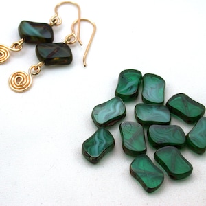 May include: Gold-tone earrings with dark green, rectangular beads and spiral accents. A collection of similar green beads with white marbling are also present. The jewelry is set against a white background.