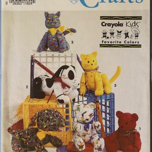 May include: Simplicity Crafts pattern 7552 featuring Crayola Kids Favorite Colors. The envelope displays illustrations of five stuffed animals: a purple cat, a yellow cat, a black and white dog, a multi-colored dog, and a red bear.