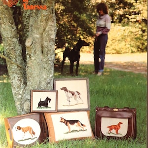 May include: A collection of dog-themed needlepoint items, including framed pictures, a pillow, and a handbag. The items feature various dog breeds in detailed embroidery. The image also includes the text "Dogs You Can Count On by Vanessa."