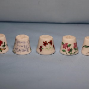 Collectible porcelain thimbles.  5 floral porcelain thimbles and 2 bird porcelain thimbles.