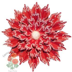 May include: A large, red paper poinsettia flower with a white center. The flower is covered in white glitter, giving it a snowy appearance.