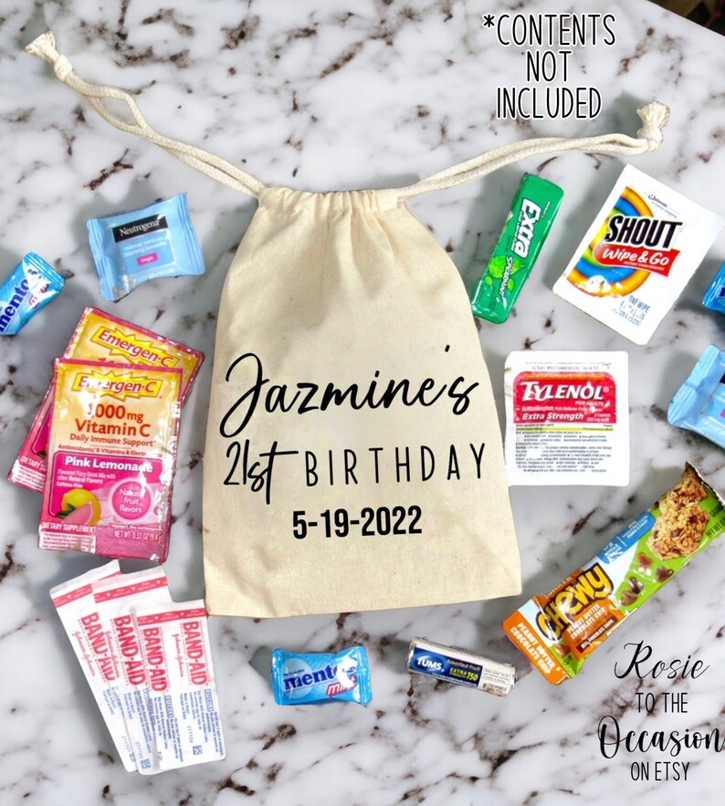 May include: A white canvas bag with the text "Jazmine's 21st Birthday 5-19-2022" printed on it. The bag is filled with various small items, including sweets, chewing gum, and medicine.