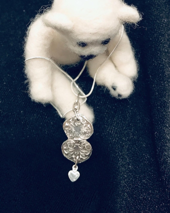 Three hearts together. Two handmade fine silver adjoined hearts with a small heart dangling. One of a kind.