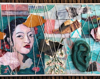 May include: Mixed media artwork featuring a portrait of a woman, torn paper, and a green ear. The artwork is composed of various textures and colors, including teal, brown, and white. White string crisscrosses the artwork, adding a unique design element.