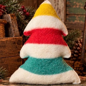 Puede incluir: Un adorno de peluche con forma de &aacute;rbol hecho de material de fieltro difuso. El dise&ntilde;o presenta rayas horizontales en amarillo, blanco, rojo, blanco, verde azulado y blanco, dispuestas desde la punta hasta la base ancha.