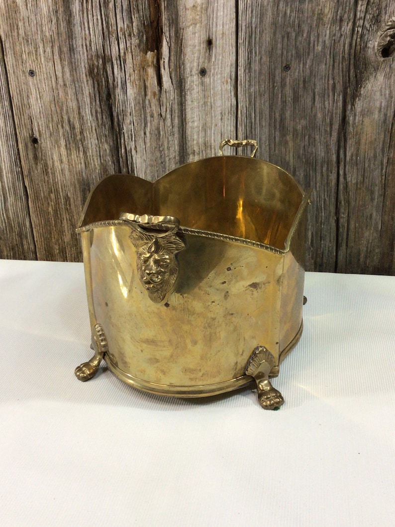 Brass footed planter with lion heads and etchings