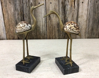 Pair vintage brass cranes with tiger cowrie shell bodies