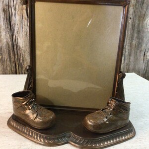 Vintage bronze baby shoe display with photo frame