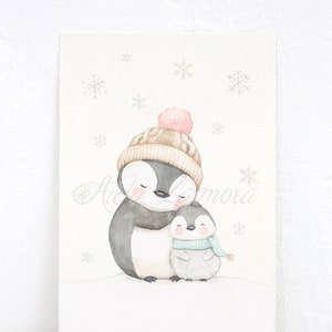 May include: A watercolour illustration of two penguins standing in the snow. The larger penguin wears a beige knit hat with a pink pom-pom, while the smaller penguin wears a light blue striped scarf. Grey snowflakes fall against a cream background.