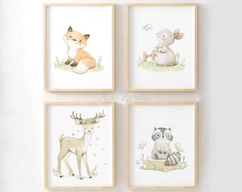 May include: Four framed wall art prints featuring watercolor illustrations of woodland animals. The top left shows a fox, the top right a rabbit, the bottom left a deer with a floral crown, and the bottom right a raccoon sitting on a tree stump.