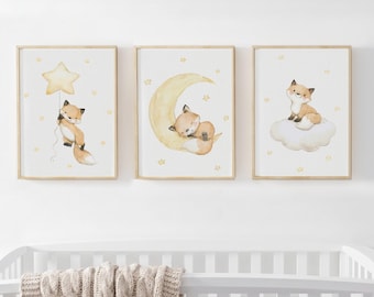 May include: Three framed wall art prints featuring watercolour illustrations of a fox. The first shows a fox holding a star balloon, the second a fox sleeping on a crescent moon, and the third a fox sitting on a cloud, all with small yellow stars.