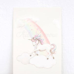 K&ouml;nnte beinhalten: Ein wei&szlig;es Einhorn mit rosa und blauem M&auml;hne und Schweif steht auf einer Wolke vor einem Regenbogen mit rosa Herzen.