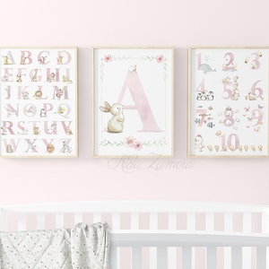 May include: Three pink and white framed prints with watercolor illustrations of animals and letters. The first print features the alphabet with animals, the second print features the letter A with a bunny, and the third print features numbers 1-10 with animals.