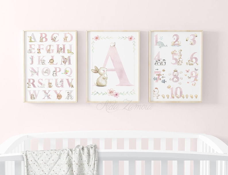 May include: Three pink and white framed prints with watercolor illustrations of animals and letters. The first print features the alphabet with animals, the second print features the letter A with a bunny, and the third print features numbers 1-10 with animals.