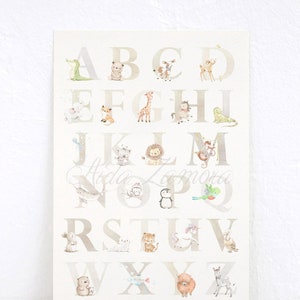 May include: A white and beige alphabet poster with animal illustrations for each letter. The letters are in a light brown font. The animals include a crocodile, bear, deer, fox, giraffe, horse, frog, koala, lion, monkey, narwhal, owl, penguin, parrot, rabbit, tiger, unicorn, sheep, bear, fish, yak, and zebra.