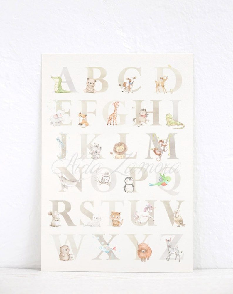 May include: A white and beige alphabet poster with animal illustrations for each letter. The letters are in a light brown font. The animals include a crocodile, bear, deer, fox, giraffe, horse, frog, koala, lion, monkey, narwhal, owl, penguin, parrot, rabbit, tiger, unicorn, sheep, bear, fish, yak, and zebra.
