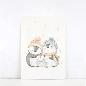 May include: A watercolour illustration of a penguin family consisting of two adults and one chick standing together. The penguins wear knit hats and scarves in shades of beige, grey, and blue. The background is white with light grey snowflakes.