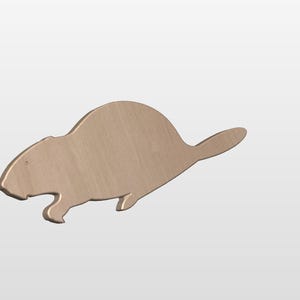 May include: A wooden beaver-shaped cutout, light brown in colour with a smooth finish. The beaver is shown in profile, with its tail and body shape clearly visible. The cutout is designed to stand alone, possibly for decoration.