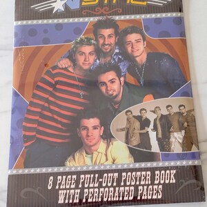 Peut inclure: Un livre de posters détachable *NSYNC de 8 pages avec des pages perforées. La couverture présente une photo de groupe des cinq membres du groupe, avec le logo en haut. Le fond a un motif circulaire violet et orange avec des étoiles blanches.
