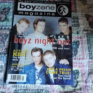 May include: A magazine cover for Boyzone, featuring a group of young men. The title reads "boyzone magazine" with "boyz night out" in red. Additional text includes "ACTION MEN" and "WIN A DREAM COME TRUE!" on the cover.
